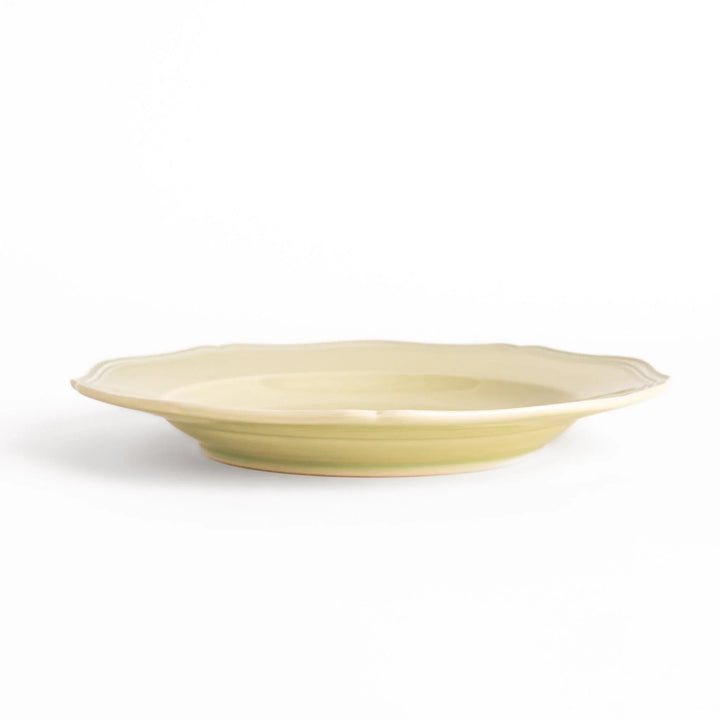 Pretty green dinner plate with a delicate scalloped edge, ideal for showcasing your culinary creations.