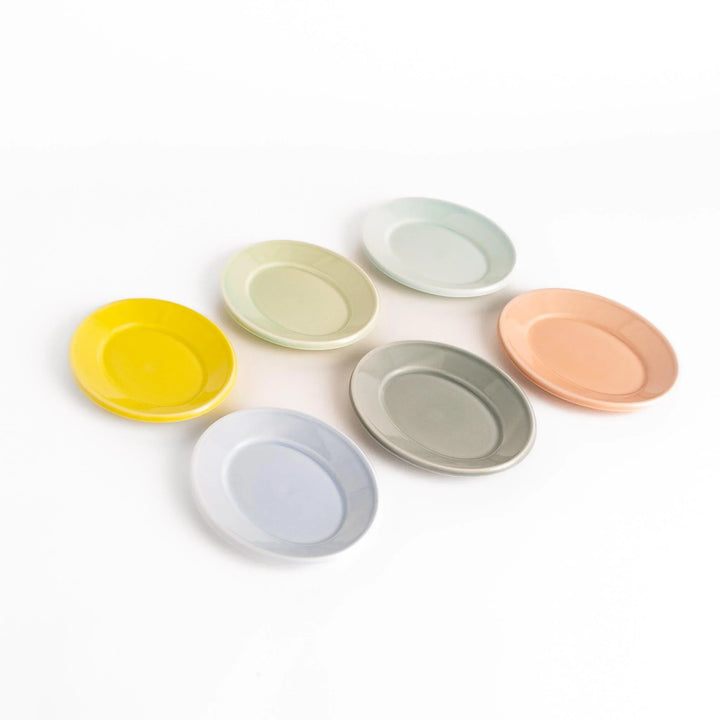 Six Japanese ceramic oval dessert plates in pastel tones of yellow green blue gray and peach ideal for everyday dining.