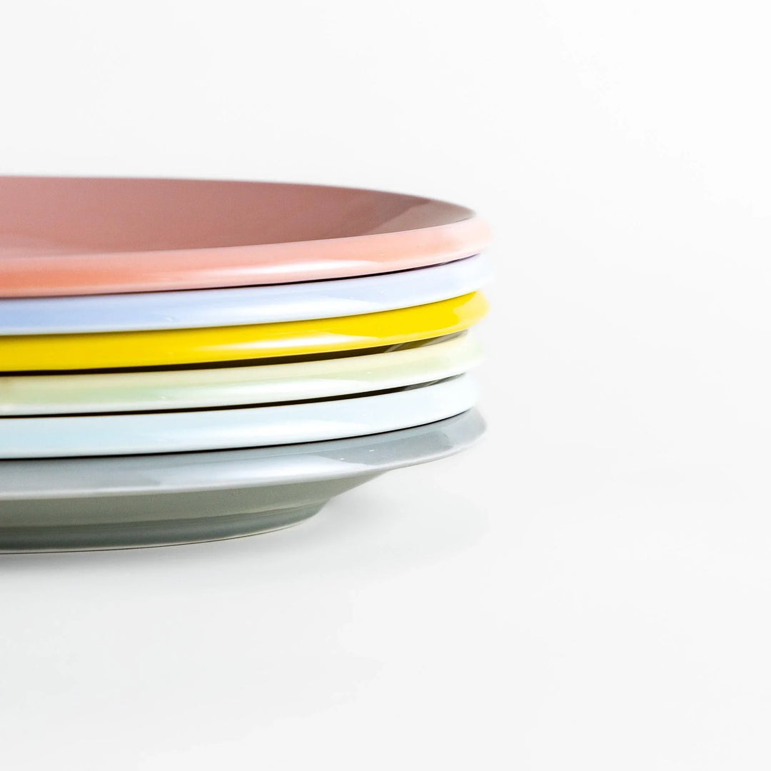 Stack of Japanese oval dinner plates in soft pastel tones with a smooth glossy finish, perfect for relaxed modern dining