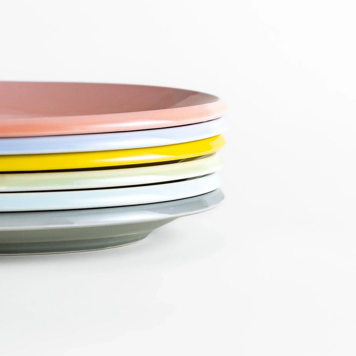 Stack of Japanese oval dinner plates in soft pastel tones with a smooth glossy finish, perfect for relaxed modern dining