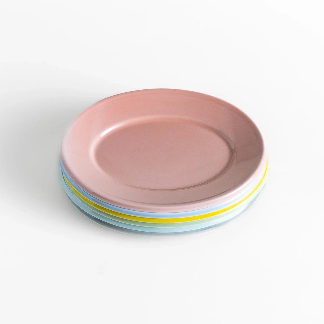 Stack of Japanese oval salad plates in soft pastel hues with a glossy finish, adding warmth and color to everyday dining