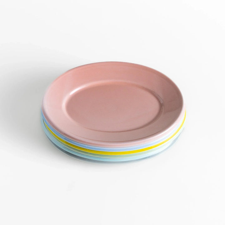 Stack of Japanese oval salad plates in soft pastel hues with a glossy finish, adding warmth and color to everyday dining