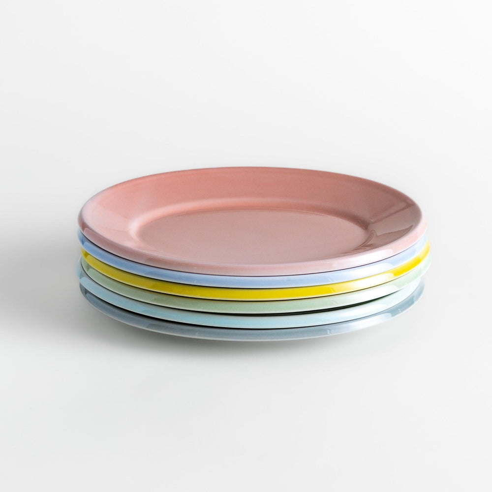 Stack of Japanese oval salad plates in soft pastel hues with a glossy finish, adding warmth and color to everyday dining
