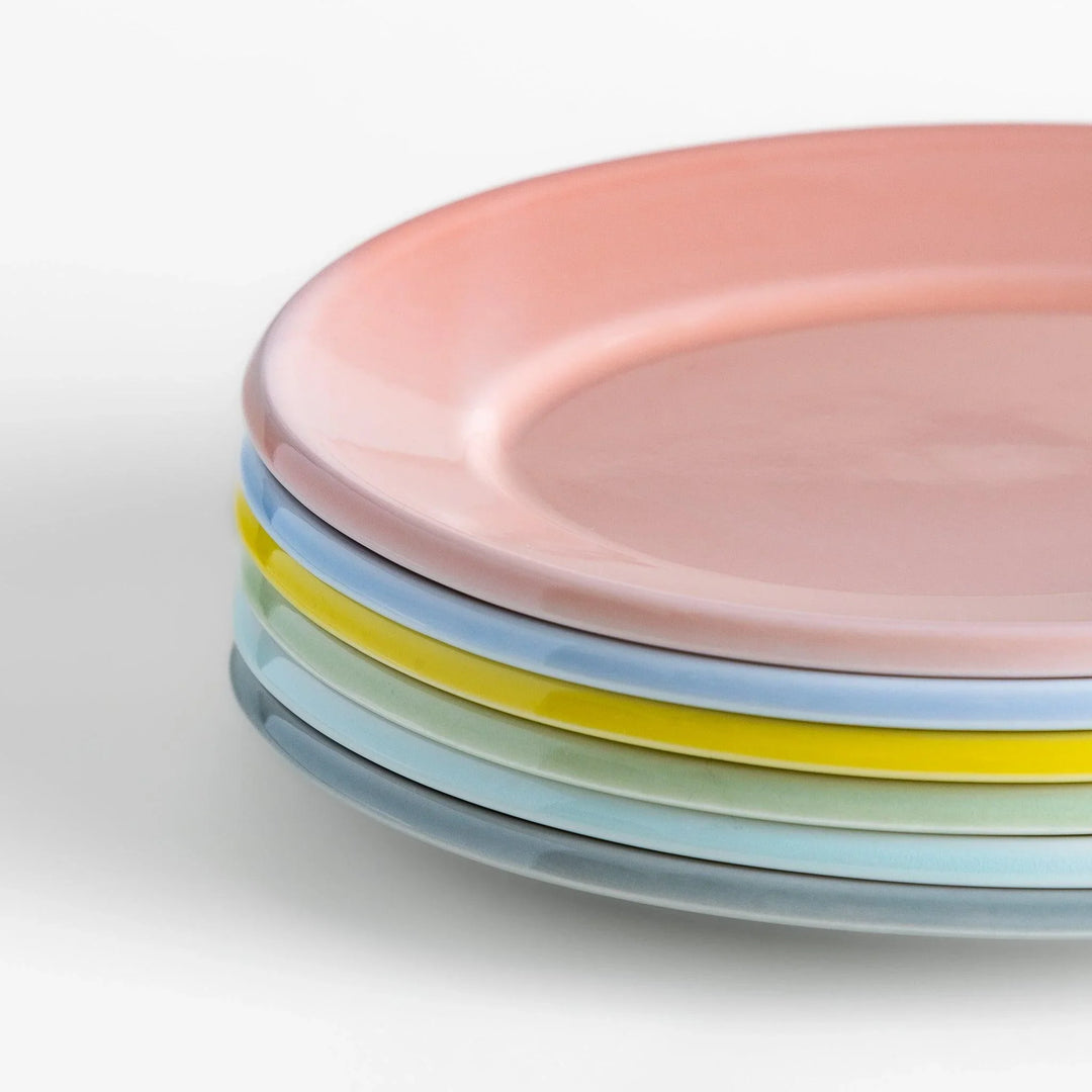 Stack of Japanese oval salad plates in soft pastel hues with a glossy finish, adding warmth and color to everyday dining