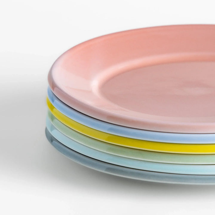 Stack of Japanese oval salad plates in soft pastel hues with a glossy finish, adding warmth and color to everyday dining