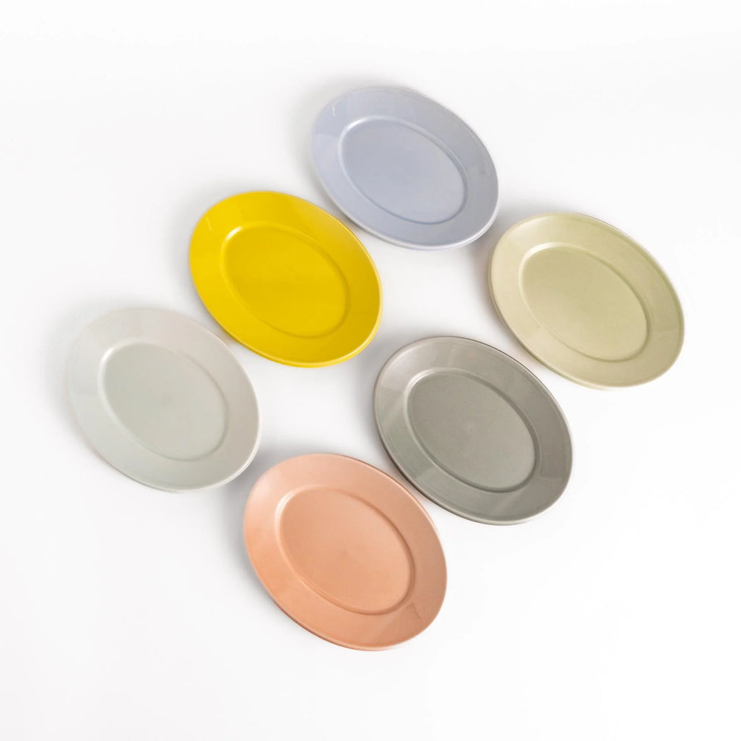 Japanese ceramic oval salad plate in pastel tones of yellow blue green gray and peach displayed neatly on a white background.