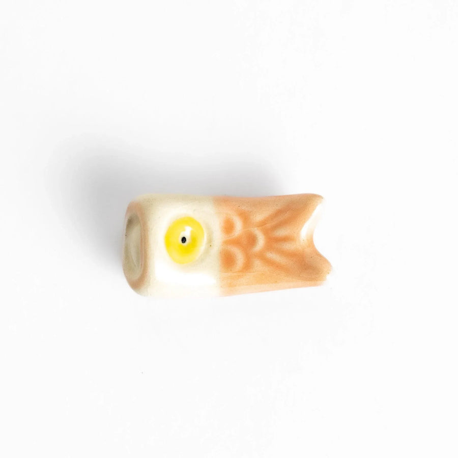 Peach carp streamer chopstick rest with a playful yellow eye design.