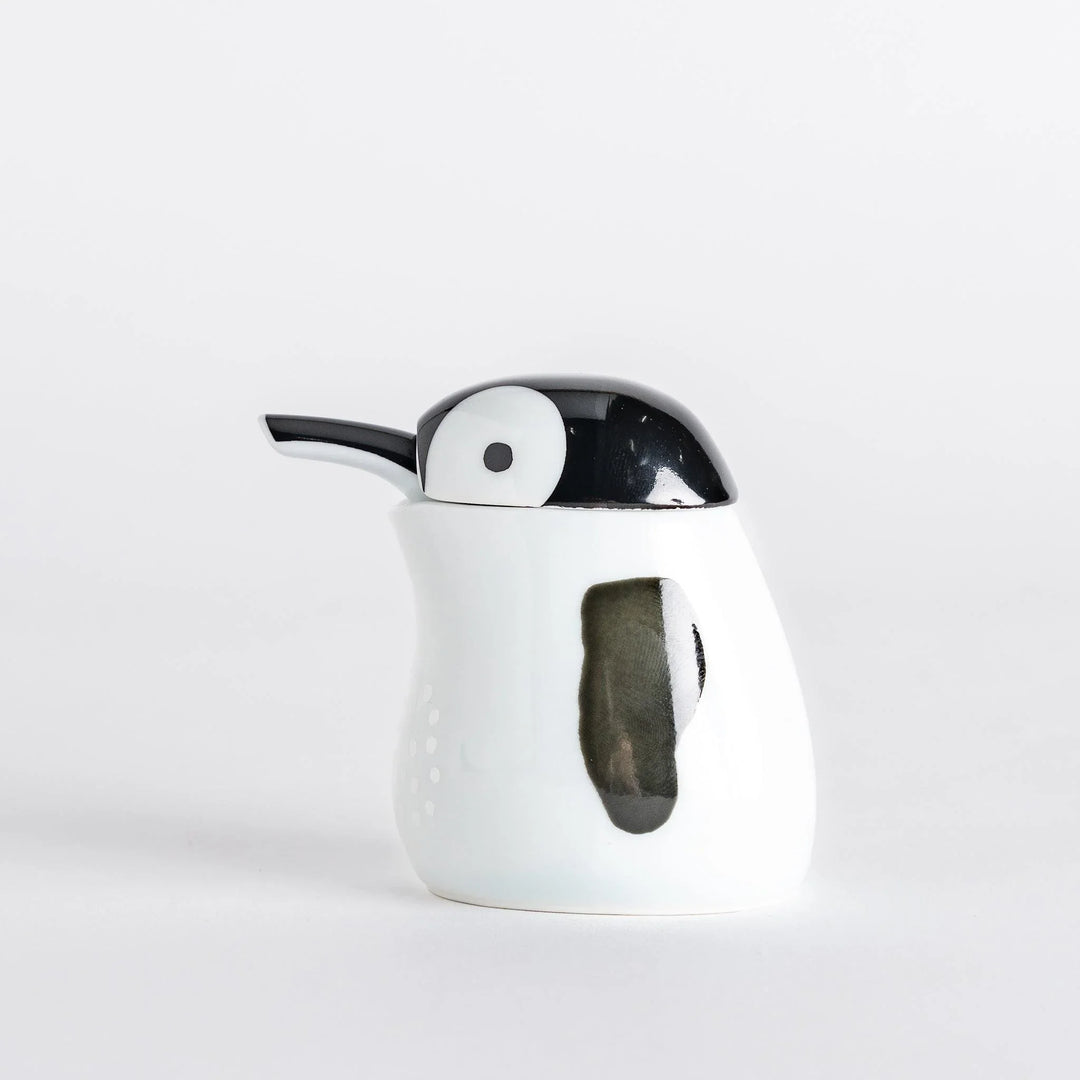Side view of the Penguin Soy Sauce Dispenser, highlighting its white body and black spout.
