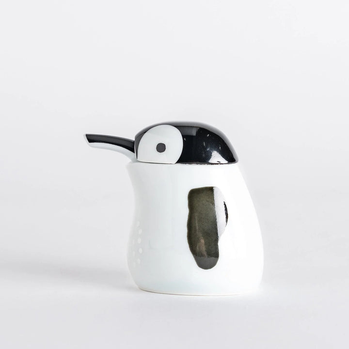 Side view of the Penguin Soy Sauce Dispenser, highlighting its white body and black spout.