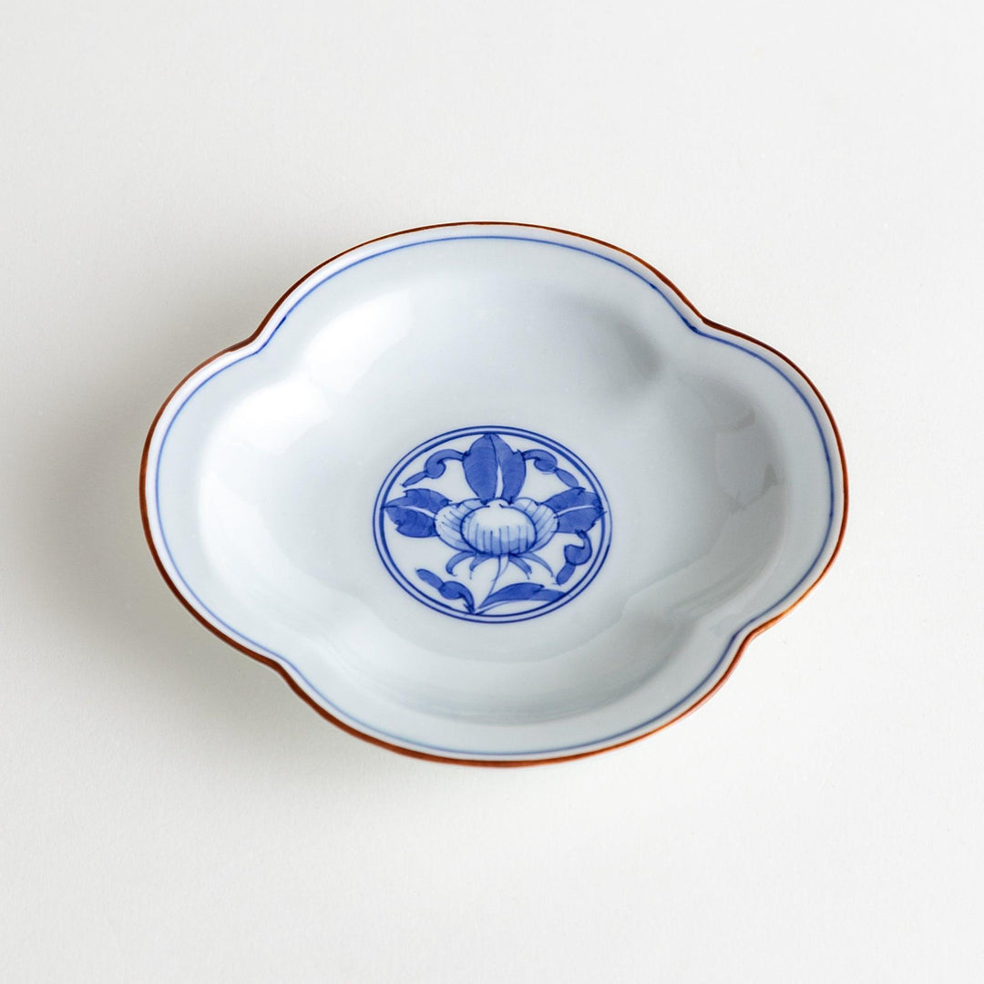 A blue and white porcelain dish with a floral motif in the center, shaped like a cloud.
