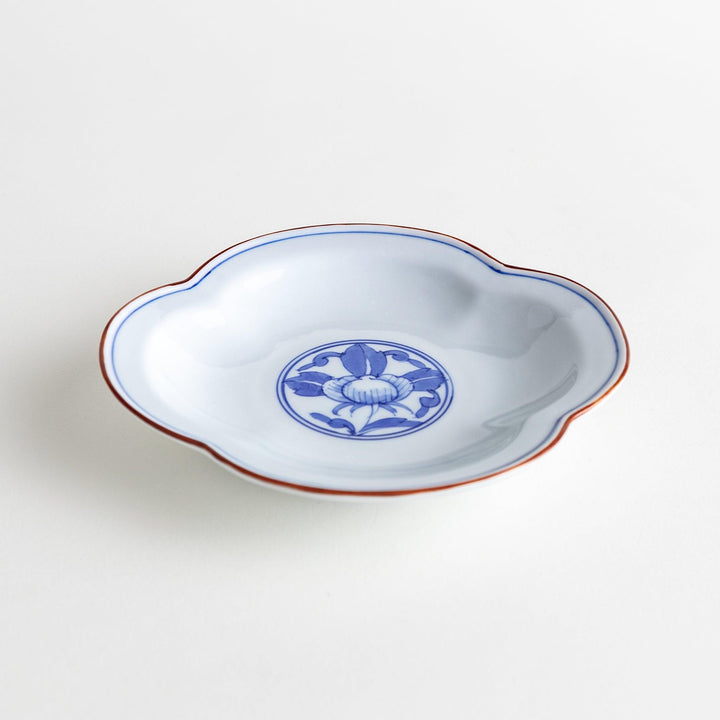 A blue and white porcelain dish with a floral motif in the center, shaped like a cloud.
