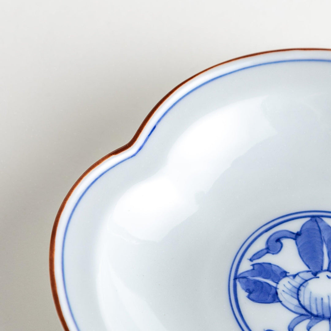 A blue and white porcelain dish with a floral motif in the center, shaped like a cloud.