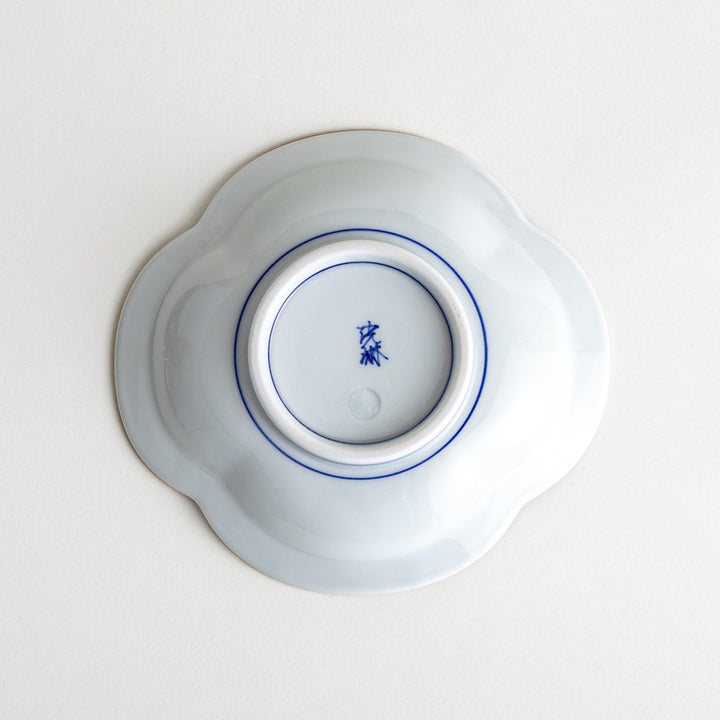 A blue and white porcelain dish with a floral motif in the center, shaped like a cloud.