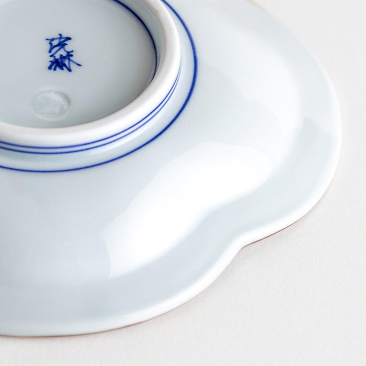A blue and white porcelain dish with a floral motif in the center, shaped like a cloud.