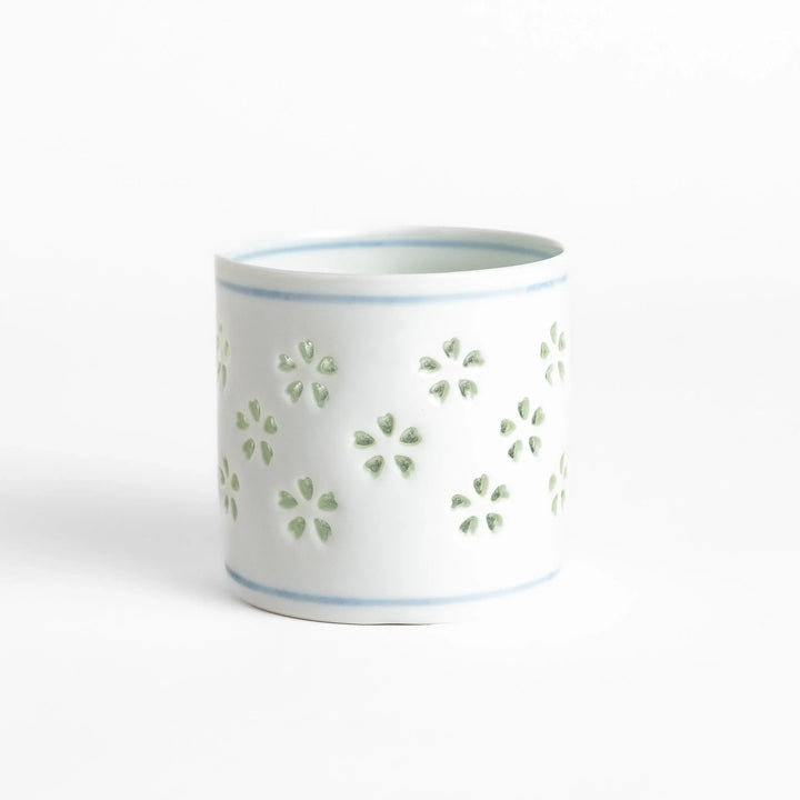 Unique ceramic glass featuring a delicate cut-out floral design, perfect for adding a touch of elegance to any table.