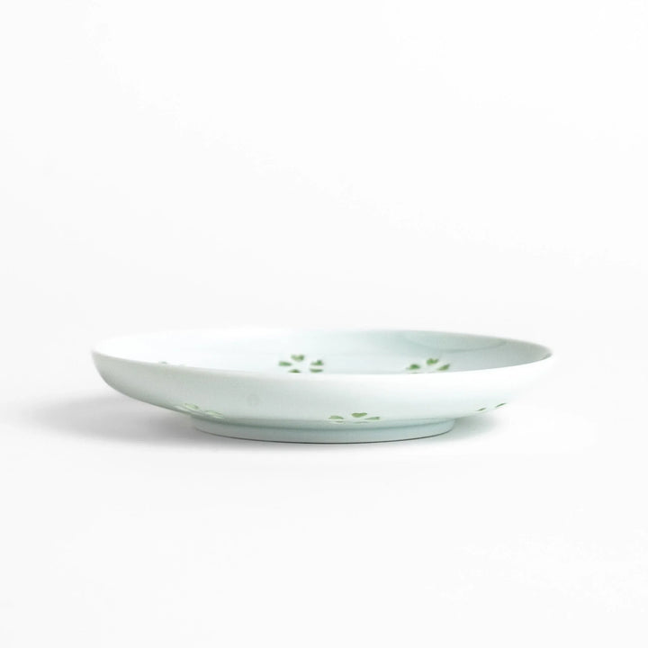 Japanese teacup and saucer set with petal cutouts in pale green and white porcelain for soft elegant look.