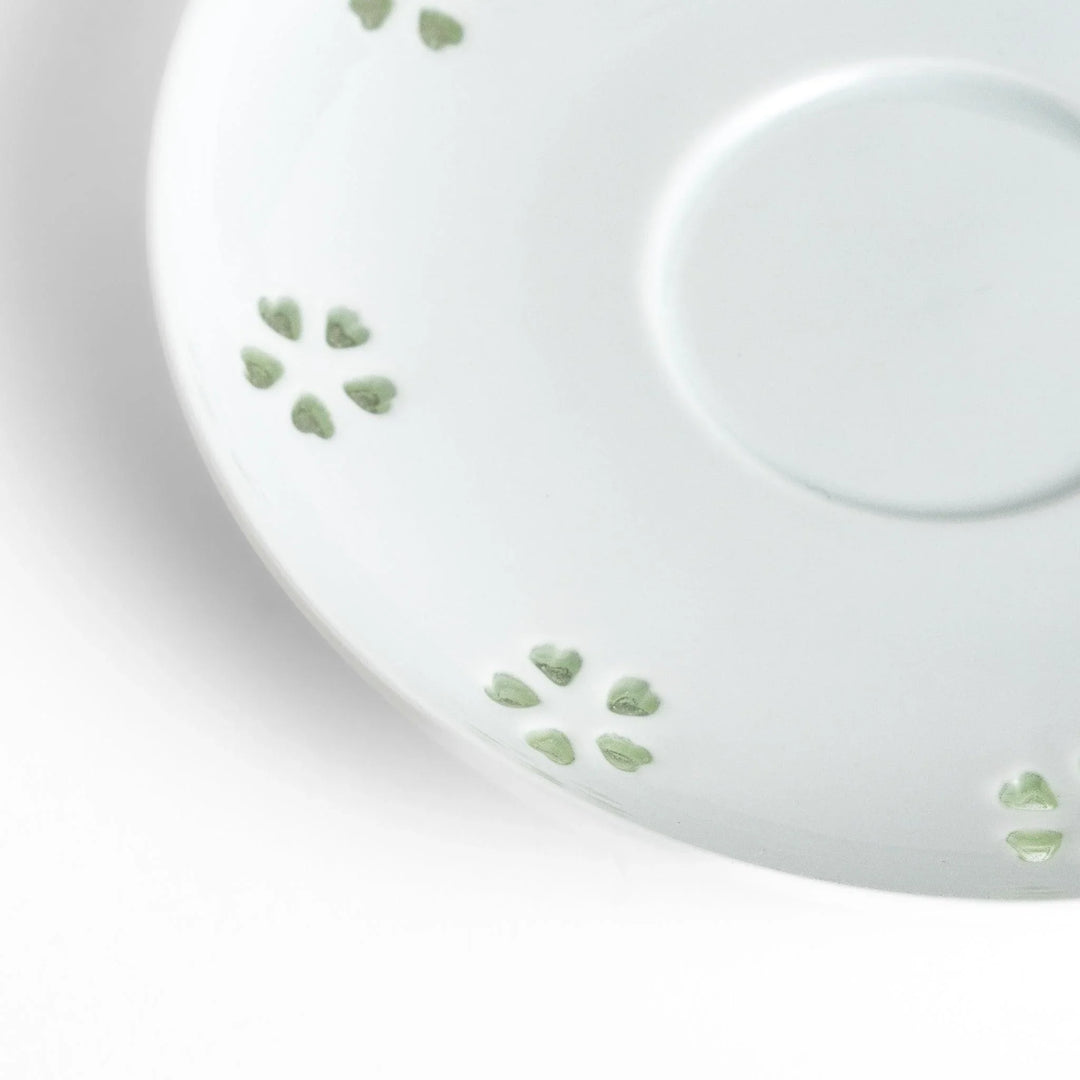 Japanese teacup and saucer set with petal cutouts in pale green and white porcelain for soft elegant look.