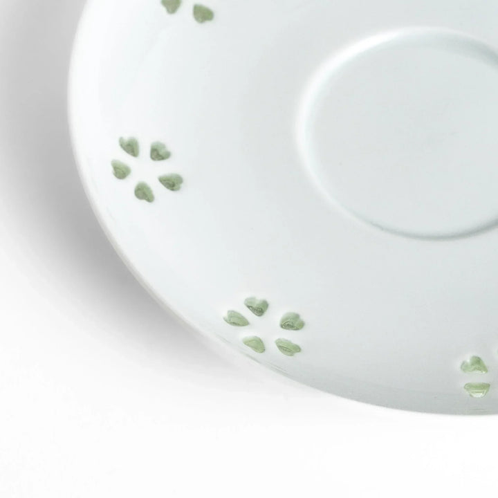 Japanese teacup and saucer set with petal cutouts in pale green and white porcelain for soft elegant look.