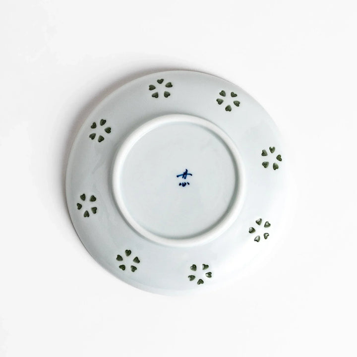 Japanese teacup and saucer set with petal cutouts in pale green and white porcelain for soft elegant look.