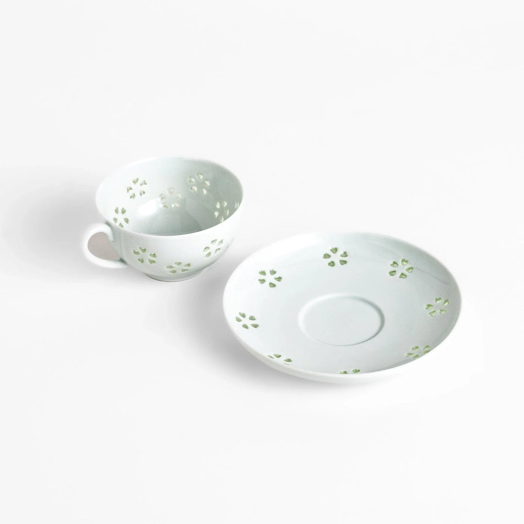 Japanese teacup and saucer set with petal cutouts in pale green and white porcelain for soft elegant look.