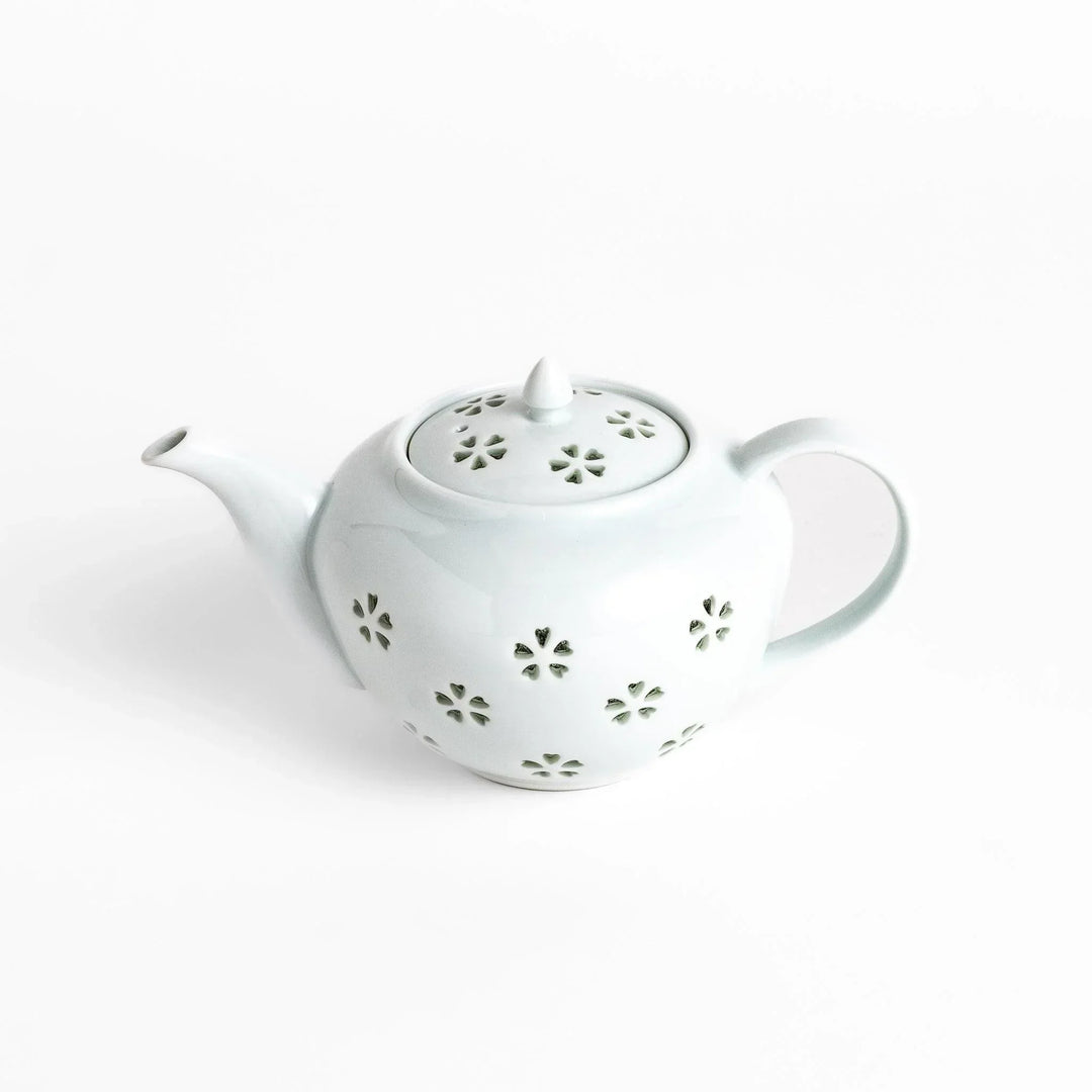 Elegant Japanese porcelain teapot with petal cutouts pointed lid and smooth handle for refined tea time.