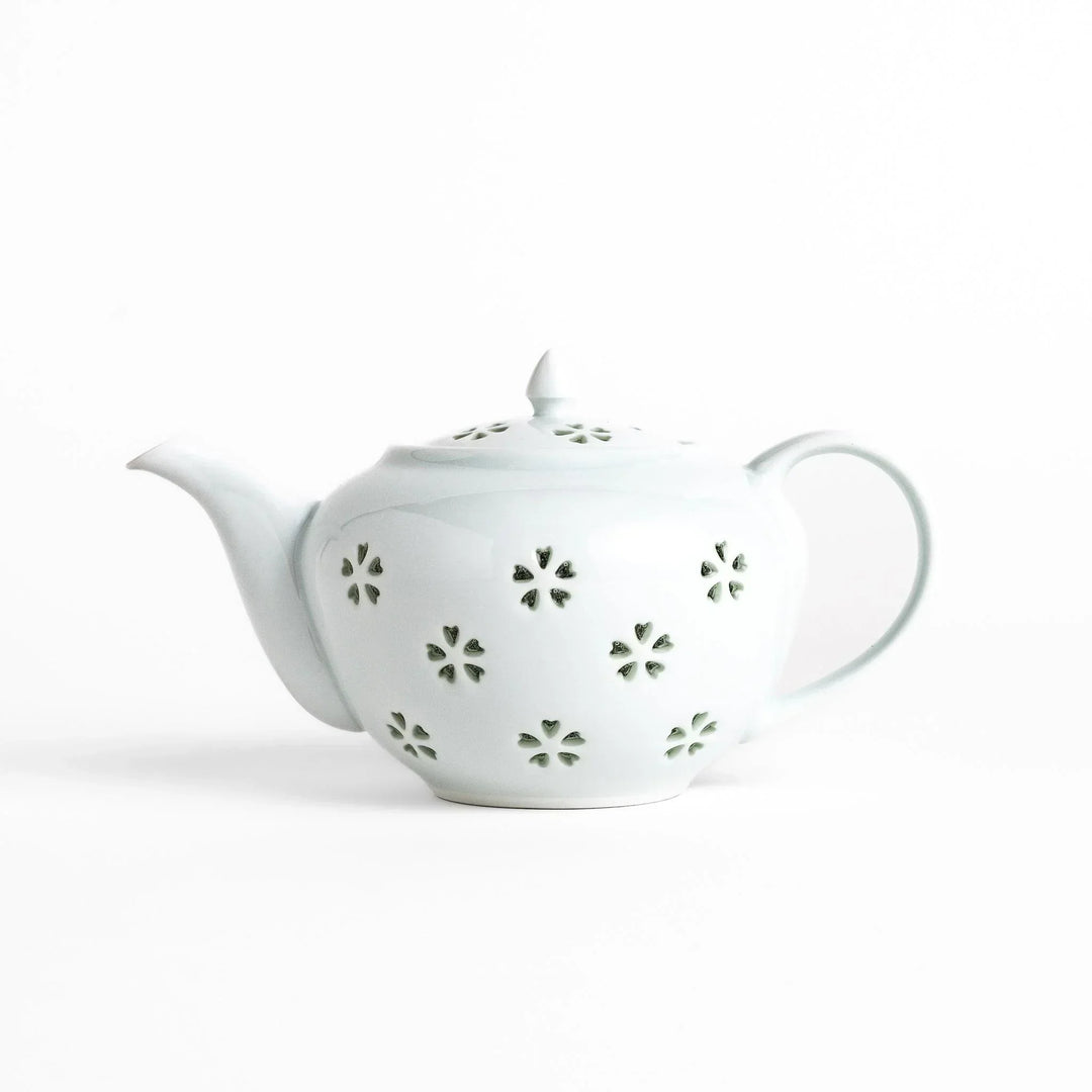 Elegant Japanese porcelain teapot with petal cutouts pointed lid and smooth handle for refined tea time.