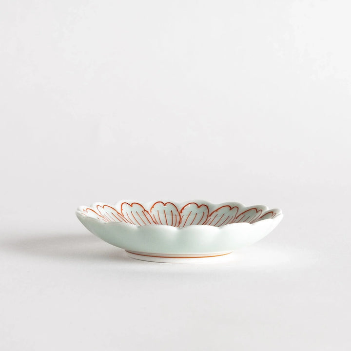 A small round dessert bowl with a delicate blue chrysanthemum pattern and scalloped edges.