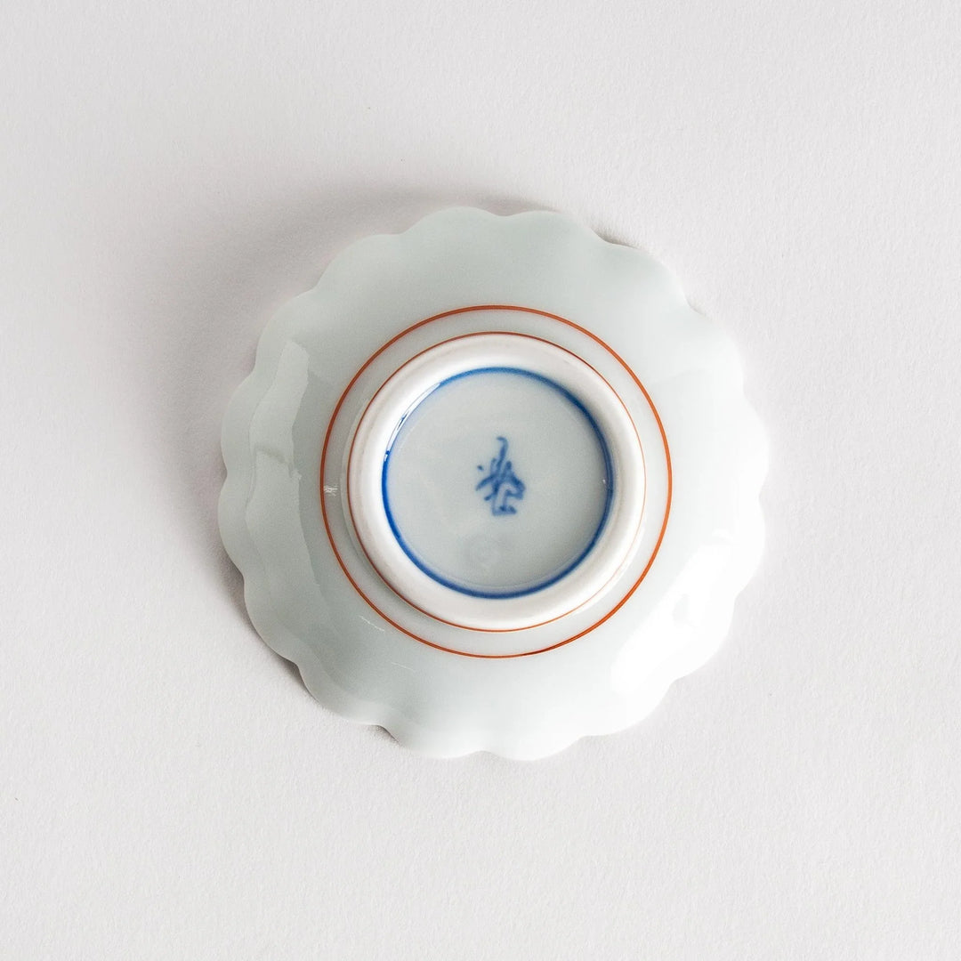 A small round dessert bowl with a delicate blue chrysanthemum pattern and scalloped edges.