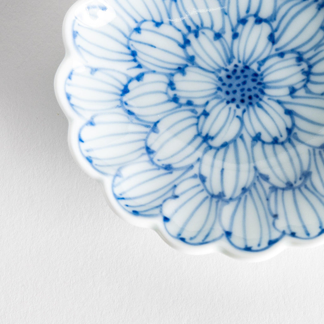 A small round dessert bowl with a delicate blue chrysanthemum pattern and scalloped edges.