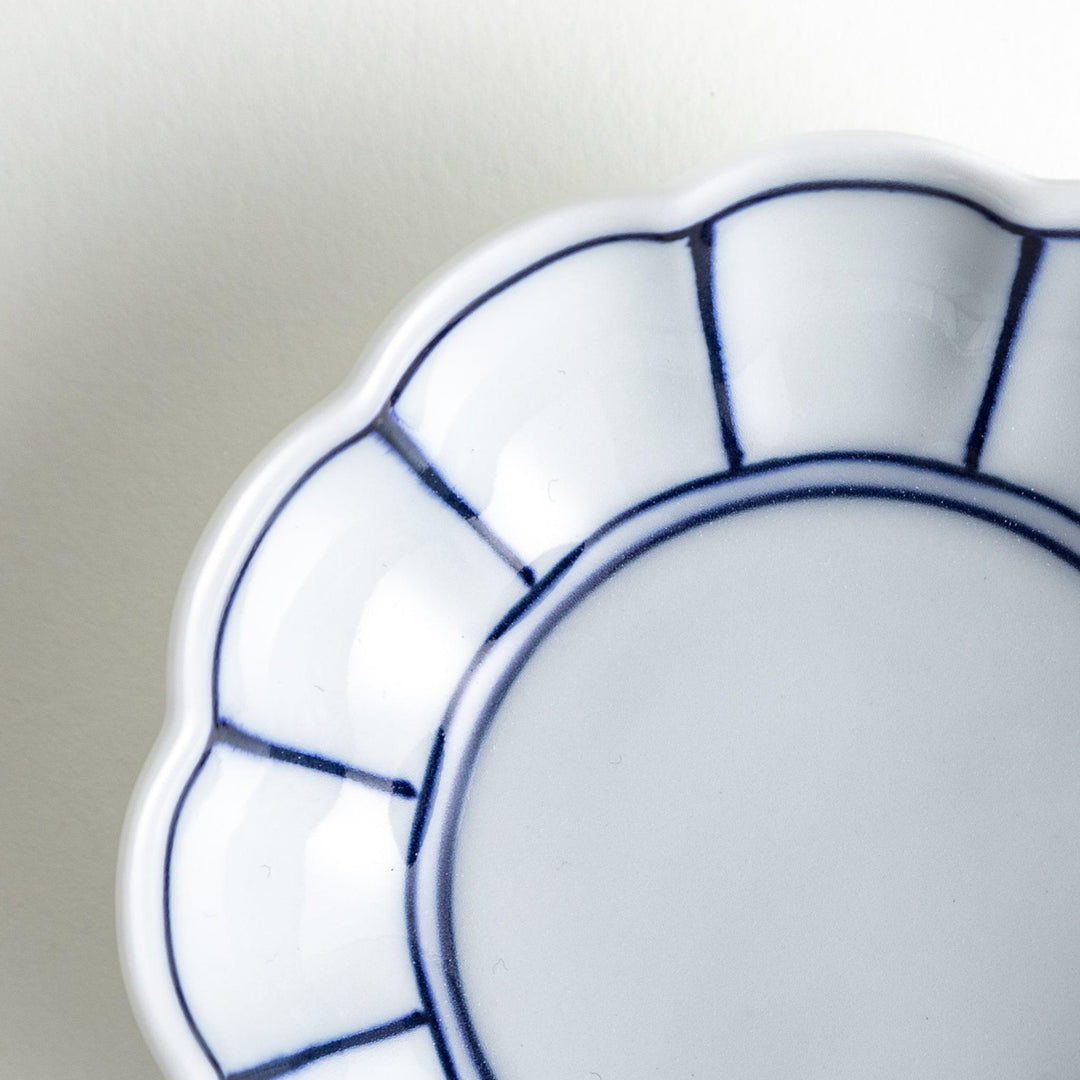 Small white porcelain condiment bowl with blue or red radiating lines for simple elegant table design.