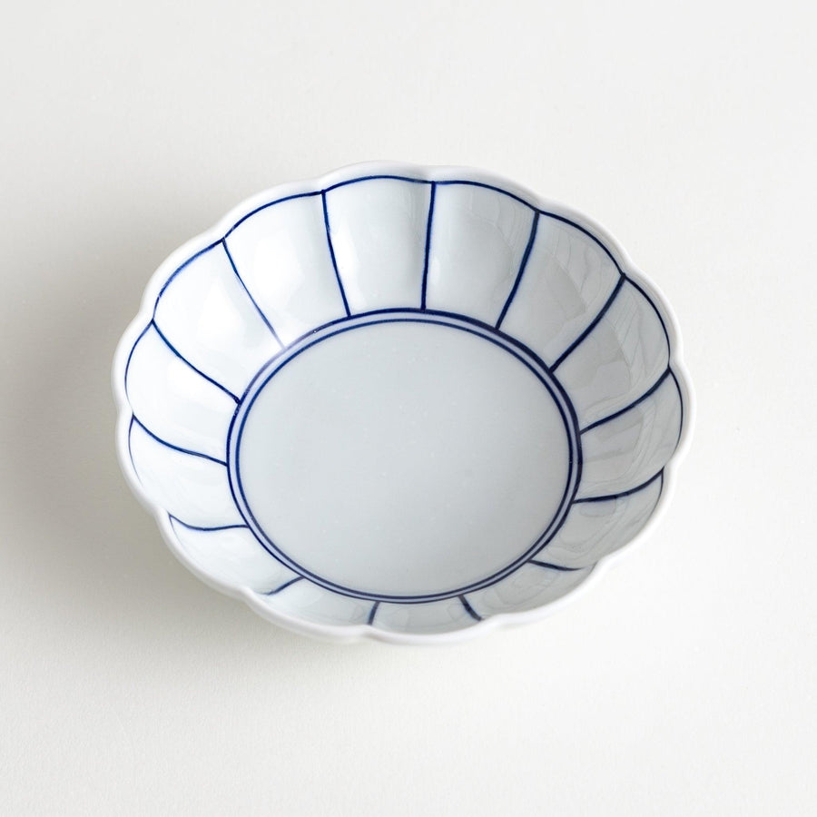 Small white porcelain dessert bowl with blue or red radiating lines for refined minimalist presentation.