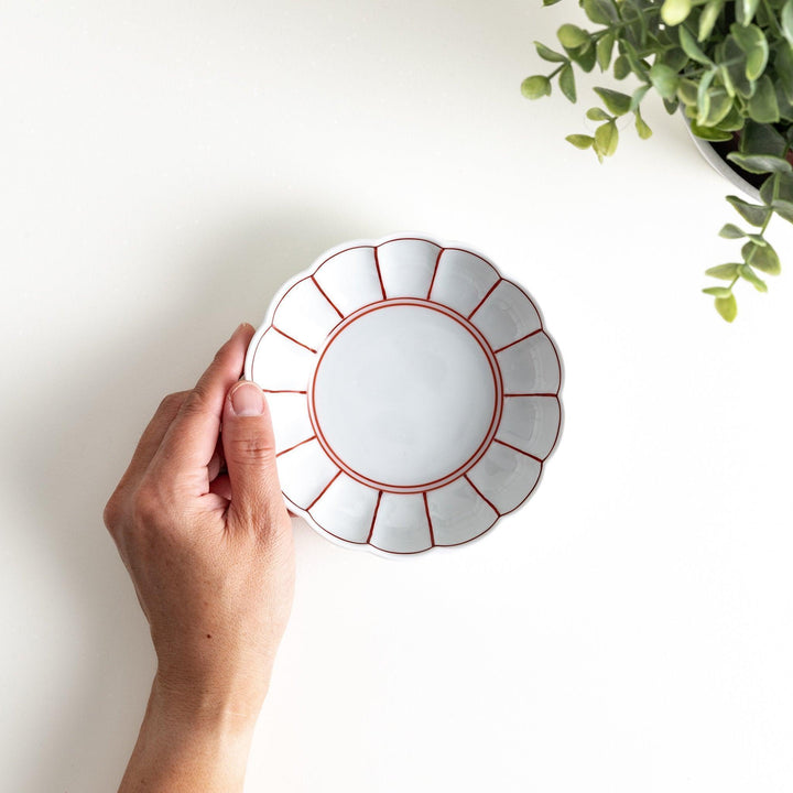 Small white porcelain dessert bowl with blue or red radiating lines for refined minimalist presentation.