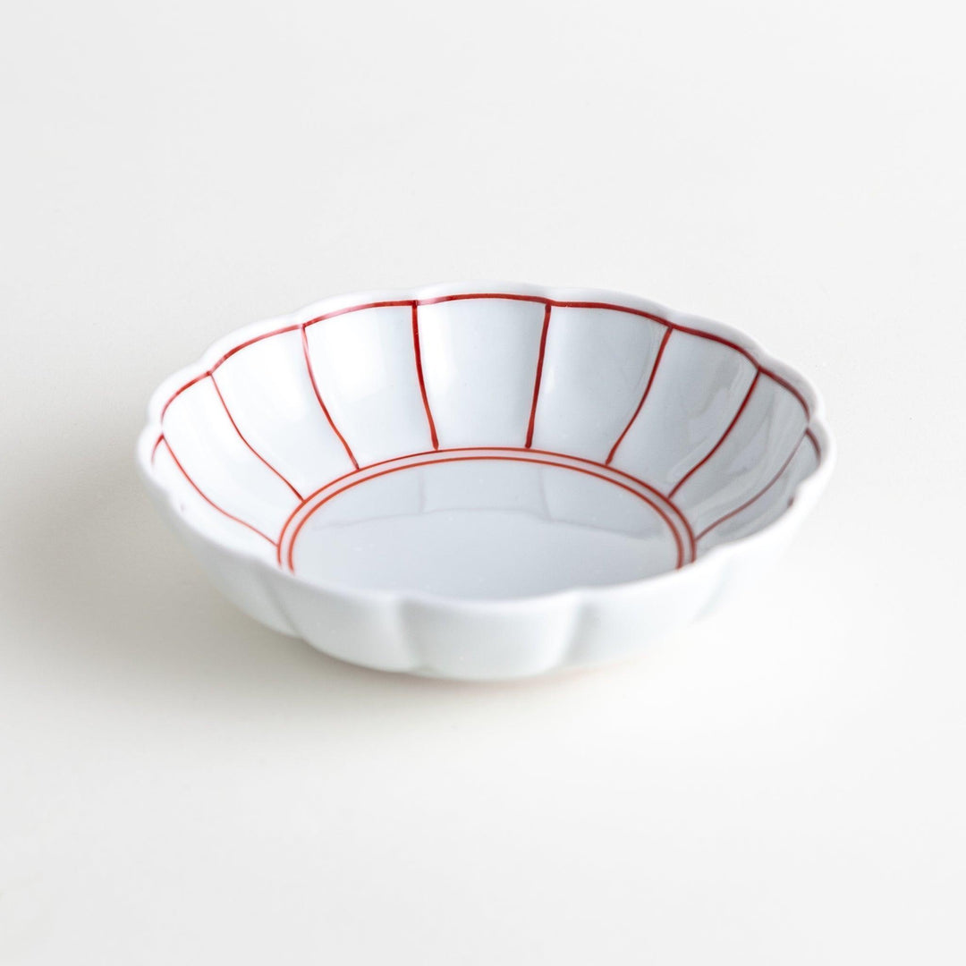 Small white porcelain dessert bowl with blue or red radiating lines for refined minimalist presentation.