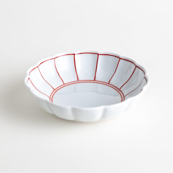 Small white porcelain dessert bowl with blue or red radiating lines for refined minimalist presentation.