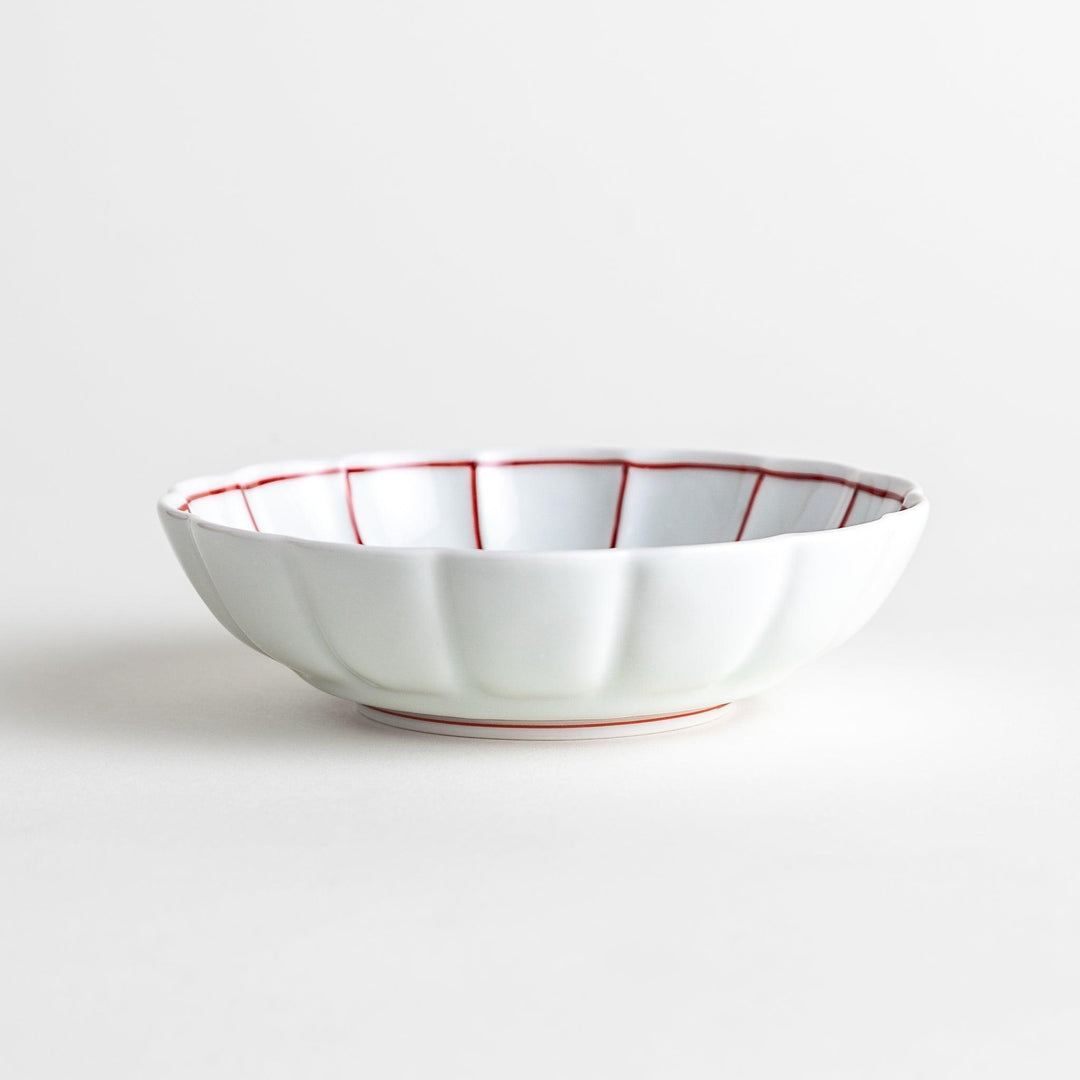 Small white porcelain dessert bowl with blue or red radiating lines for refined minimalist presentation.