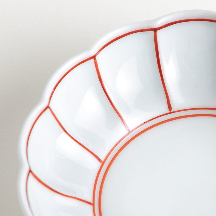Small white porcelain dessert bowl with blue or red radiating lines for refined minimalist presentation.
