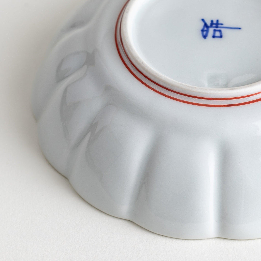 Small white porcelain dessert bowl with blue or red radiating lines for refined minimalist presentation.