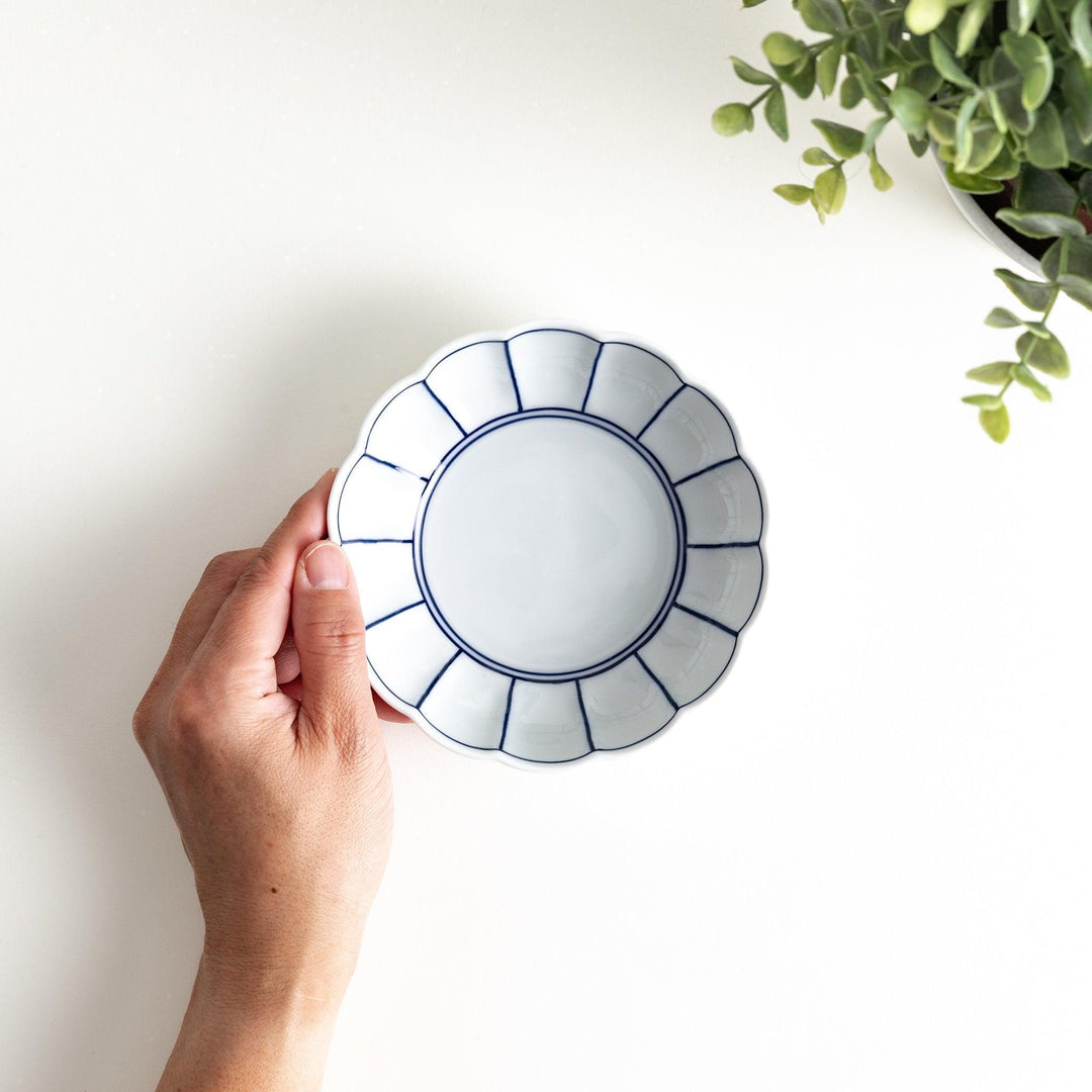Small white porcelain dessert bowl with blue or red radiating lines for refined minimalist presentation.