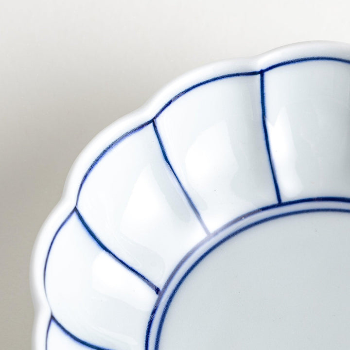 Small white porcelain dessert bowl with blue or red radiating lines for refined minimalist presentation.