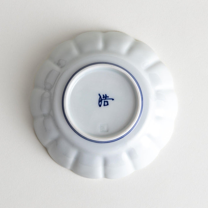 Small white porcelain dessert bowl with blue or red radiating lines for refined minimalist presentation.