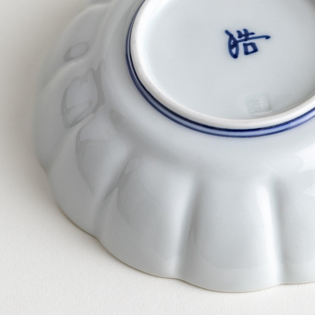 Small white porcelain dessert bowl with blue or red radiating lines for refined minimalist presentation.