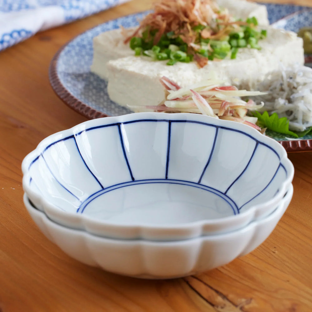 Stacked white porcelain bowls with blue lines showing Japanese minimalist design and timeless elegance.