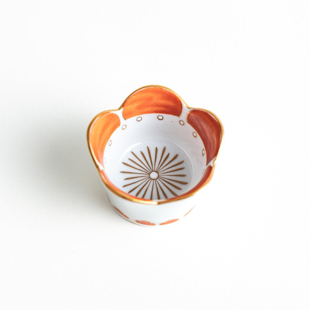 A small white bowl featuring plum pattern with gold trim.