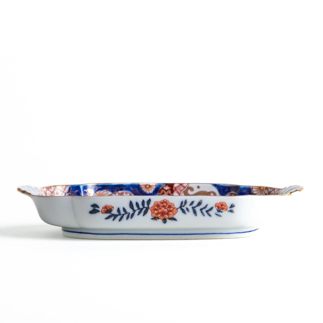 Rectangular salad plate with handles featuring cranes and trees bordered by red blue and gold patterns.