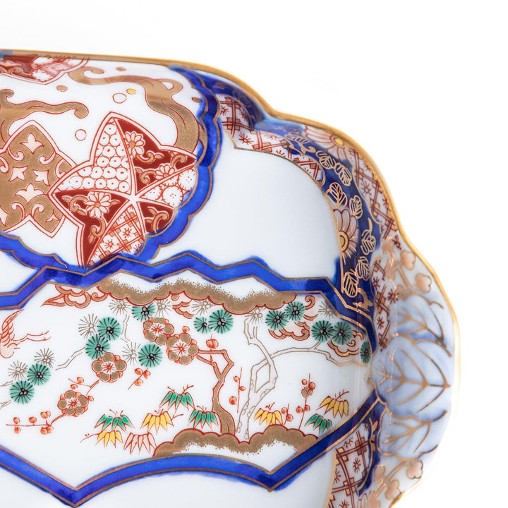 Rectangular salad plate with handles featuring cranes and trees bordered by red blue and gold patterns.