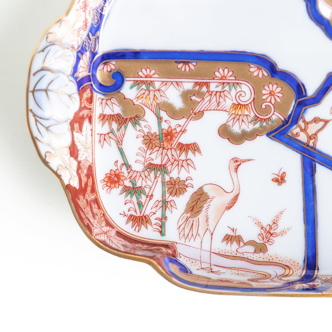 Rectangular salad plate with handles featuring cranes and trees bordered by red blue and gold patterns.