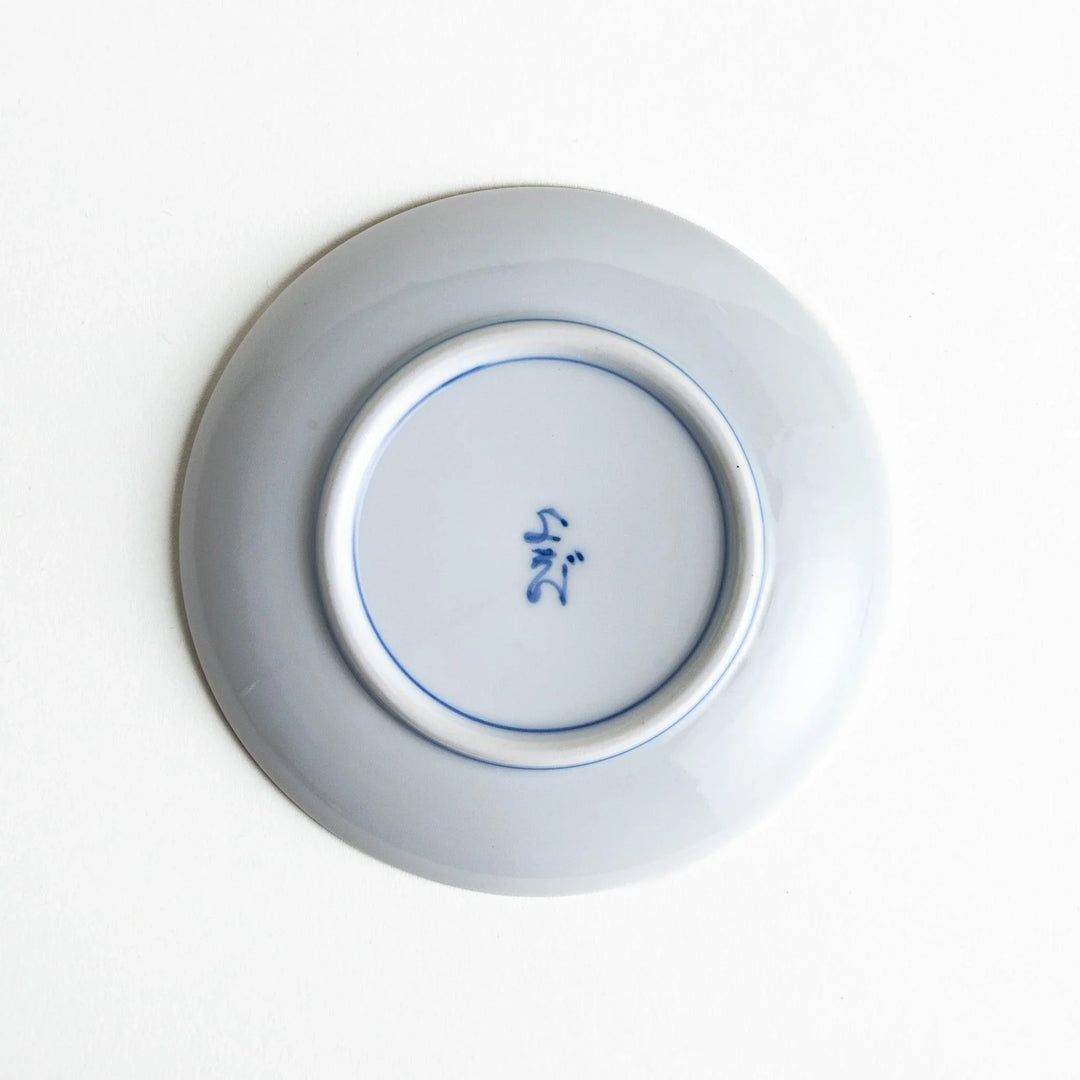 Round plate with an orange background, green leaves, and a Mount Fuji scene.