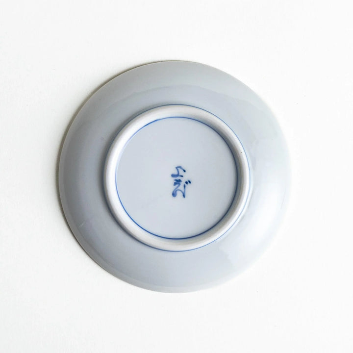 Round plate with an orange background, green leaves, and a Mount Fuji scene.