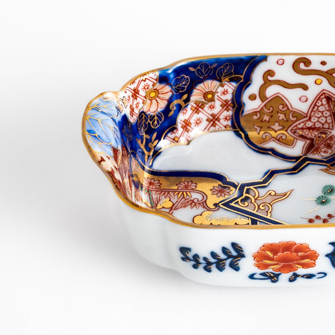Vibrant condiment bowl with pine bamboo and plum motifs cranes and gold details and flared edge design.