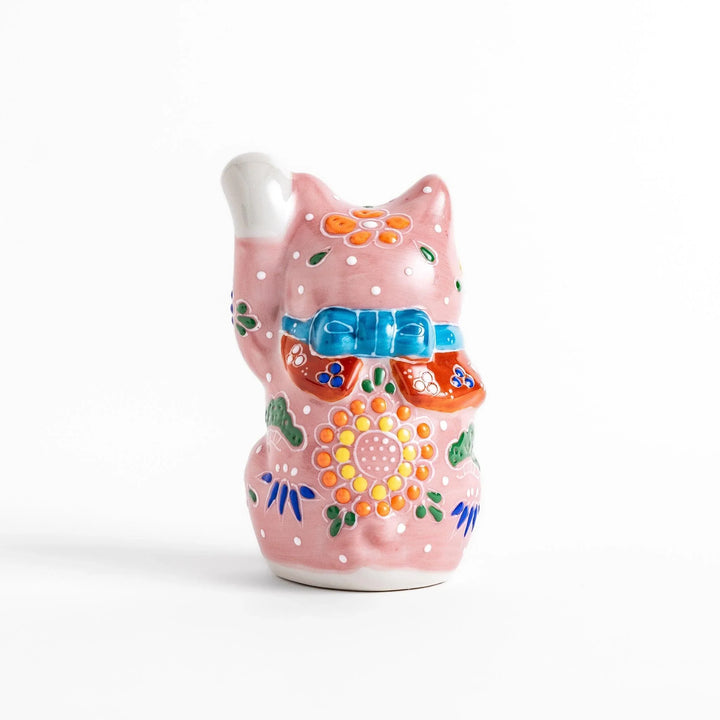 Pink blossom Maneki Neko figurine with floral patterns and gold bell symbolizing good luck and prosperity.